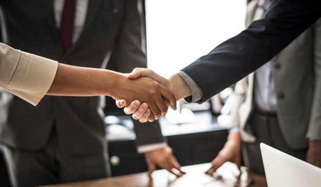 Gente de negocios dándose la mano en una sala de reuniones