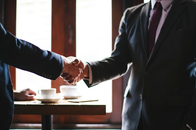 Gente de negocios dándose la mano en una sala de reuniones