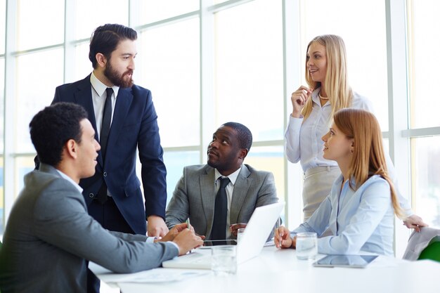 La gente de negocios escuchando a su compañero de trabajo hablando