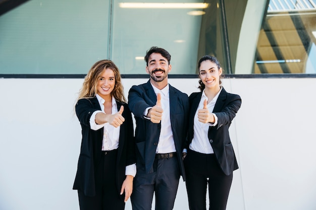 Foto gratuita gente de negocios haciendo gesto de pulgar arriba