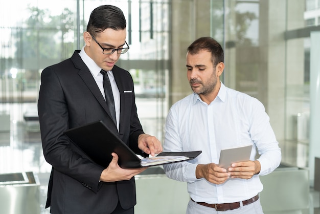 Gente de negocios infeliz leyendo informe financiero anual