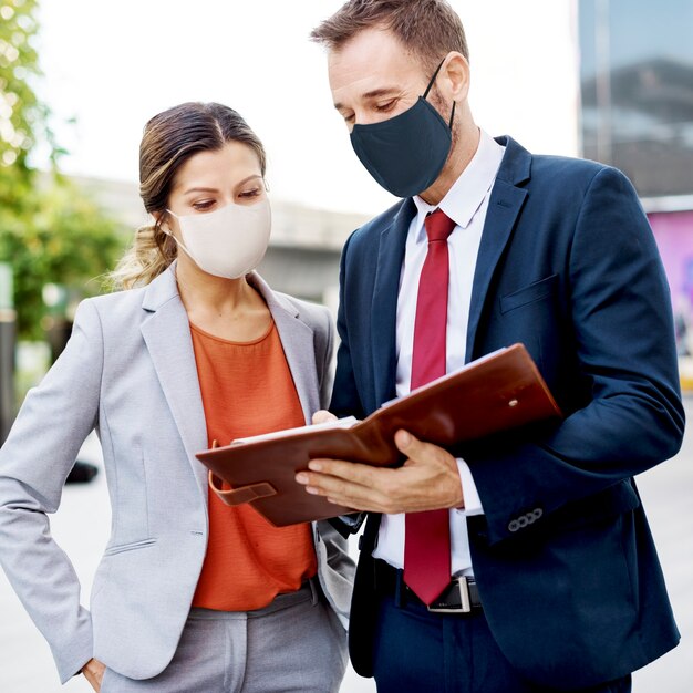 Gente de negocios en mascarilla trabajando en nueva normalidad