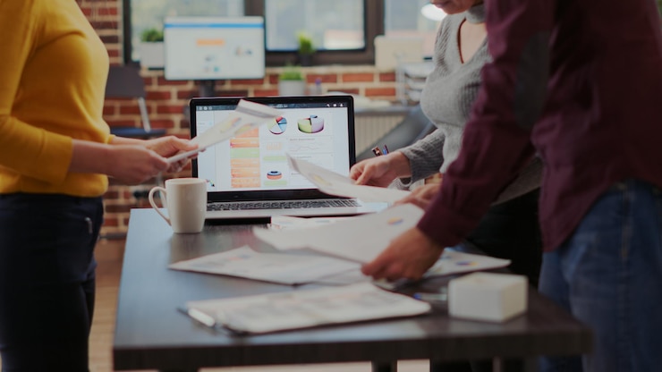 Foto gratuito gente de negocios mirando informes de proyectos en archivos para planificar una presentación exitosa con gráficos y resultados financieros. hombres y mujeres trabajando juntos para ayudar al crecimiento de la empresa. de cerca