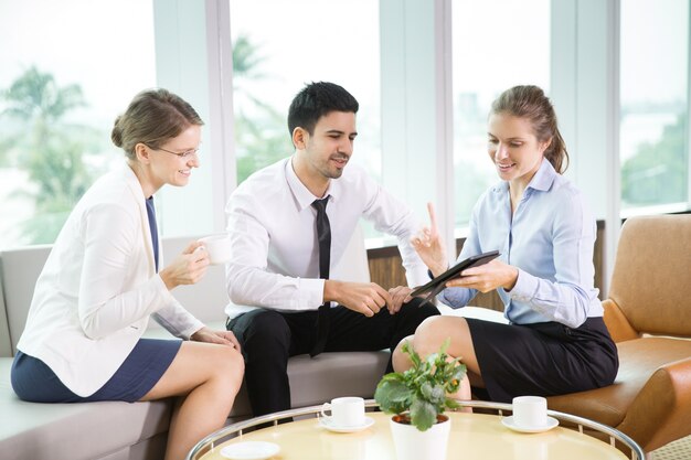 La gente de negocios que usa la tableta en el Café 1