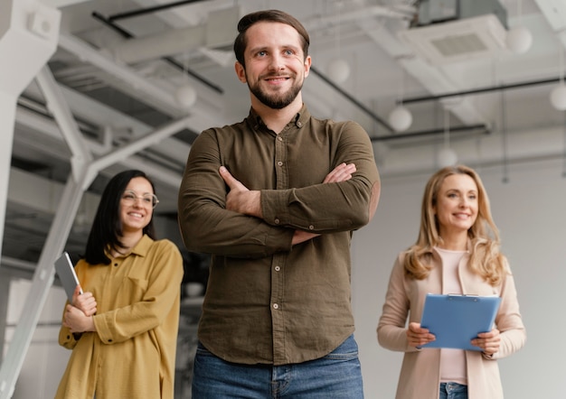 Gente de negocios sonriente de ángulo bajo posando