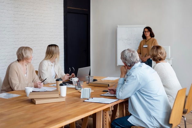 Foto gratuita gente de negocios de tiro medio en reunión