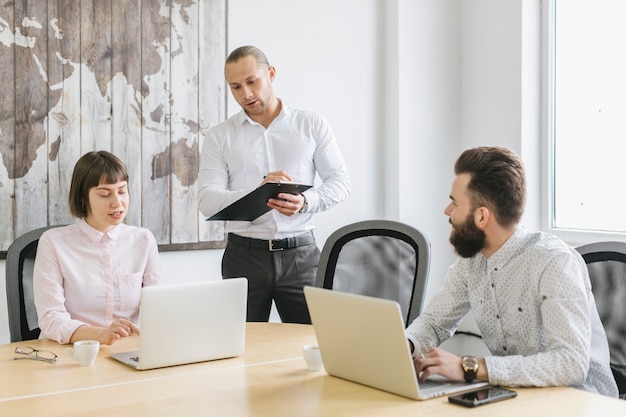 Foto gratuita gente de negocios trabajando con portátil en oficina