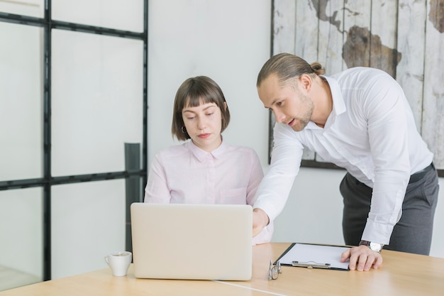 Foto gratuita gente de negocios trabajando con portátil en oficina