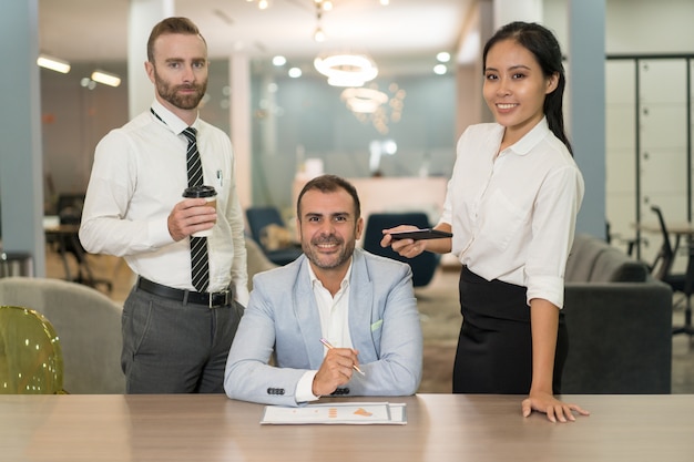 Foto gratuita gente de negocios trabajando y posando en el escritorio en la oficina