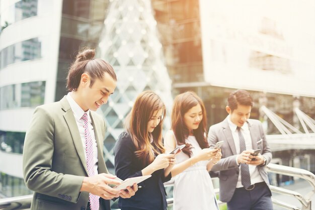 Gente de negocios utilizando el teléfono inteligente mientras están juntos