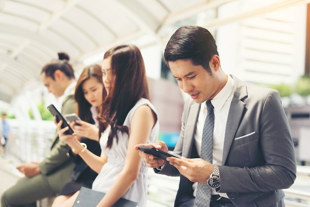 Gente de negocios utilizando el teléfono inteligente mientras están juntos