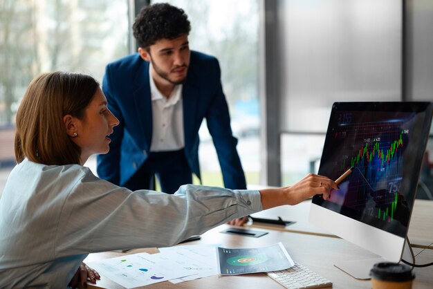 Gente en la oficina analizando y revisando gráficos financieros