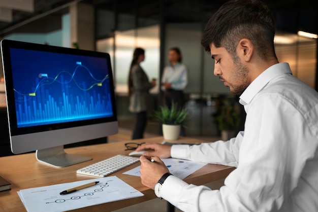 Gente en la oficina analizando y revisando gráficos financieros