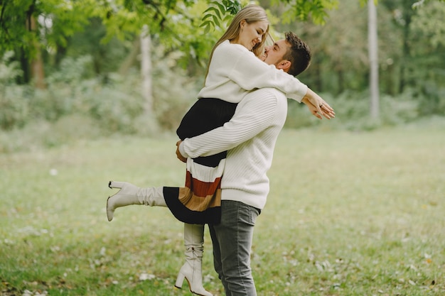 Gente en un parque. Mujer con un suéter blanco.