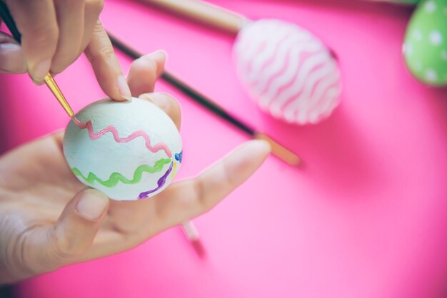 Gente pintando coloridos huevos de Pascua - concepto de celebración de vacaciones de semana Santa