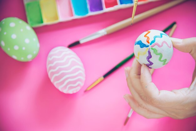 Gente pintando coloridos huevos de Pascua - concepto de celebración de vacaciones de semana Santa
