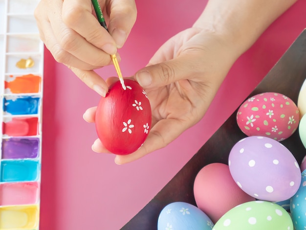 Gente pintando coloridos huevos de Pascua - concepto de celebración de vacaciones de semana Santa