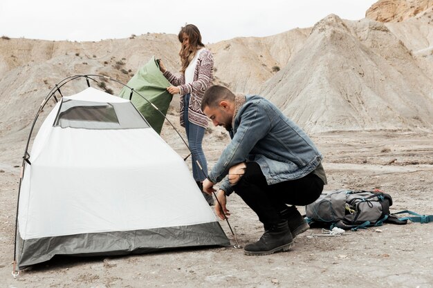 Gente de plano completo montando una carpa