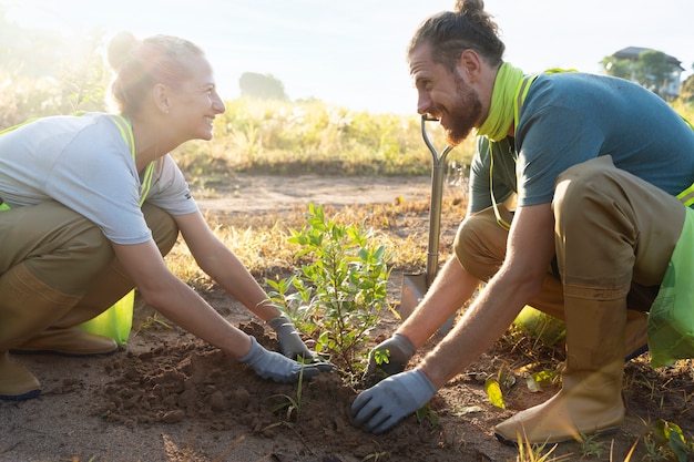 Foto gratuita gente plantando árboles en el campo