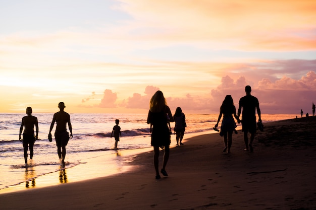 gente en la playa al atardecer.