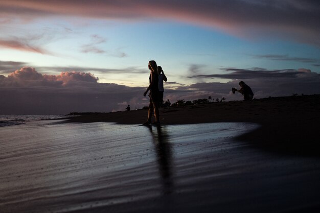 gente en la playa al atardecer.