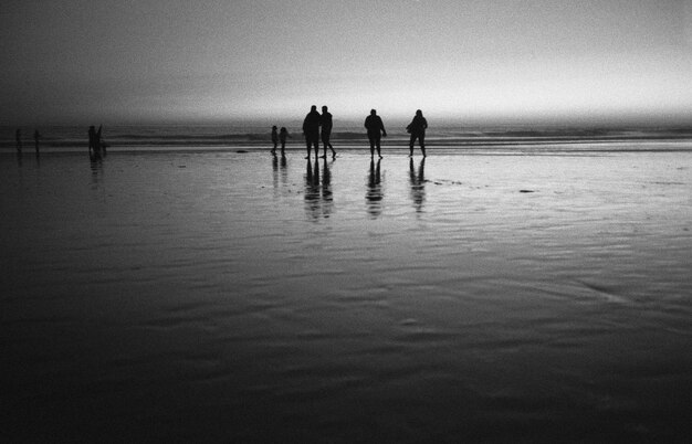 Gente en la playa al atardecer