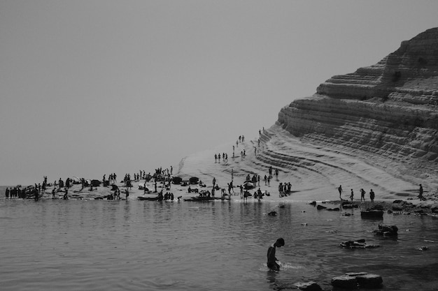 Gente en la playa en blanco y negro.