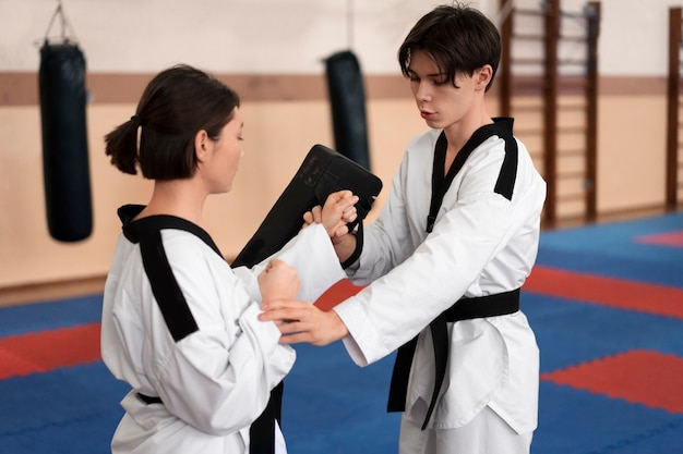 Foto gratuita gente practicando taekwondo en un gimnasio