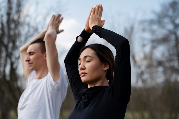 Gente practicando yoga afuera