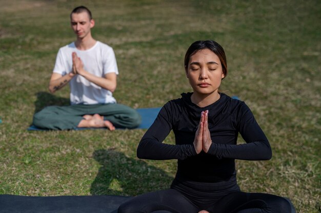 Gente practicando yoga afuera