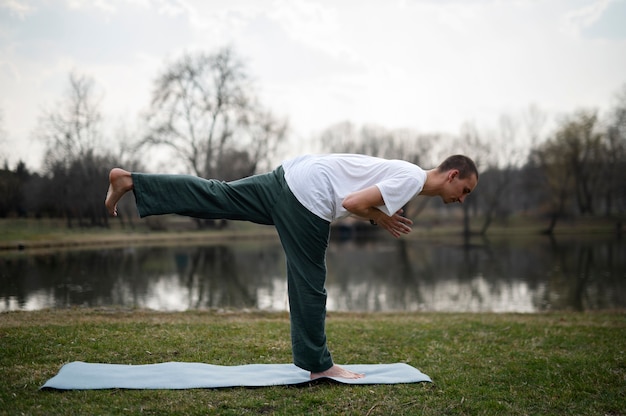 Foto gratuita gente practicando yoga afuera