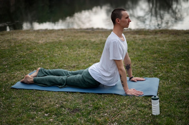 Foto gratuita gente practicando yoga afuera