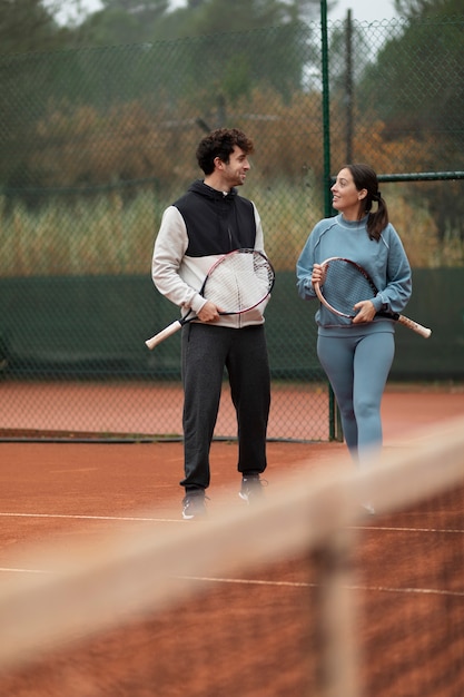 Gente preparándose para el juego de tenis en invierno