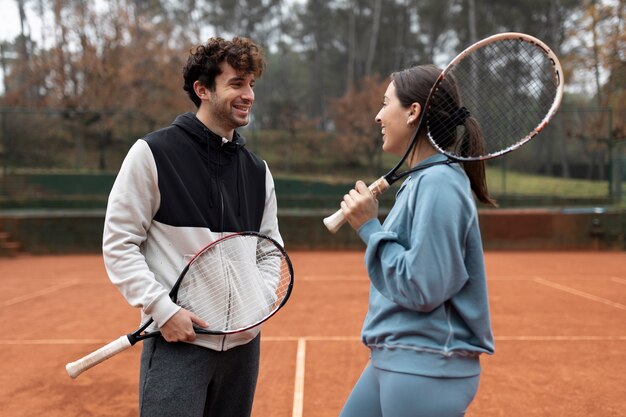 Gente preparándose para el juego de tenis en invierno