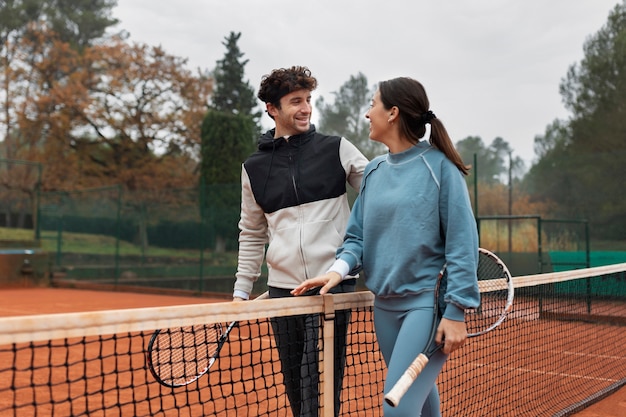 Gente preparándose para el juego de tenis en invierno