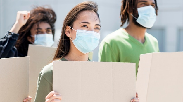 Foto gratuita gente protestando y usando máscaras médicas