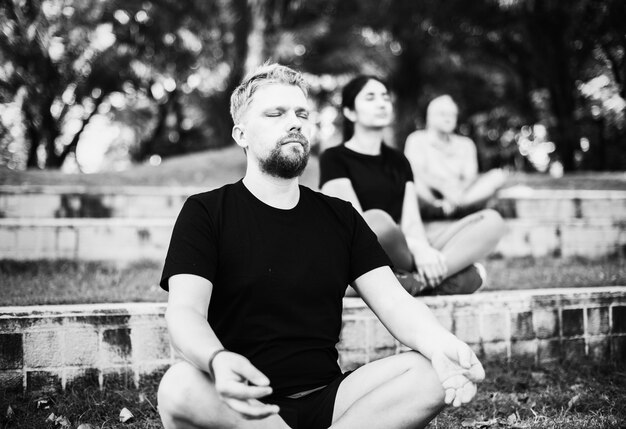 Gente que hace yoga en el parque