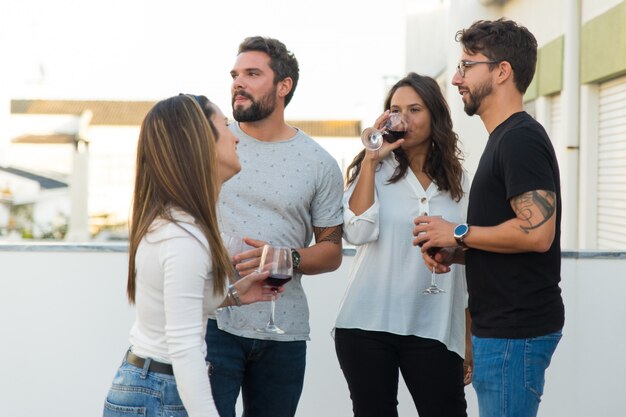 Gente relajada bebiendo vino y charlando