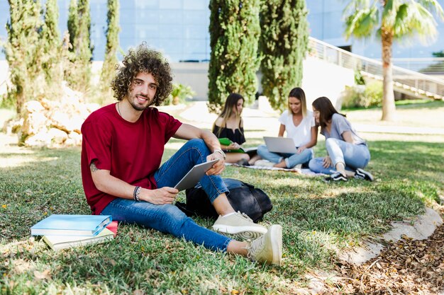 Gente sentada en campus de universidad