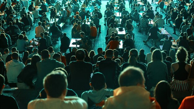 Gente sentada viendo fútbol en un lugar público por la noche