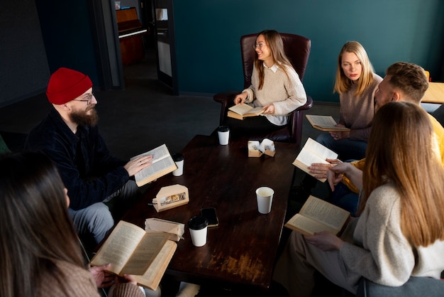 Gente sonriente de alto ángulo en el club de lectura