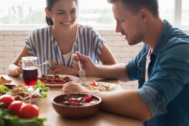 Gente sonriente comiendo juntos