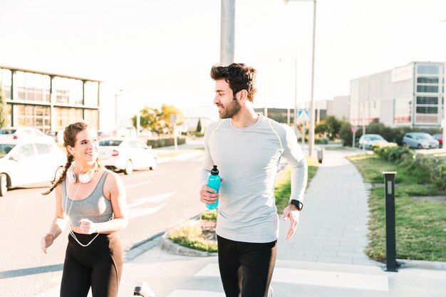 Gente sonriente corriendo en el paso de peatones