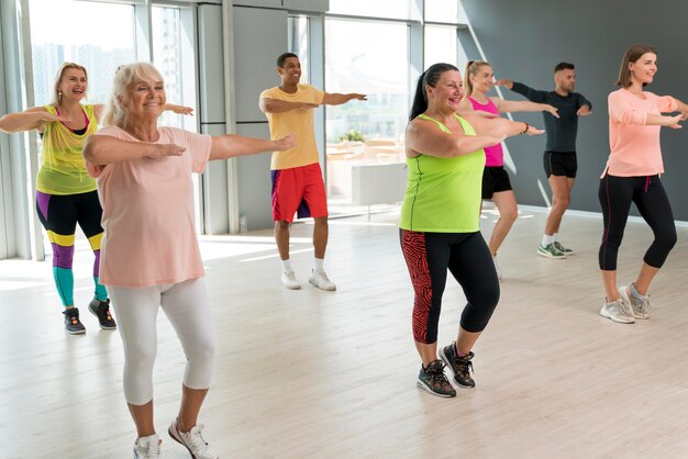 Gente sonriente divirtiéndose en clase de zumba