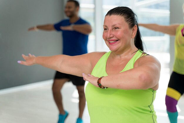 Gente sonriente divirtiéndose en clase de zumba