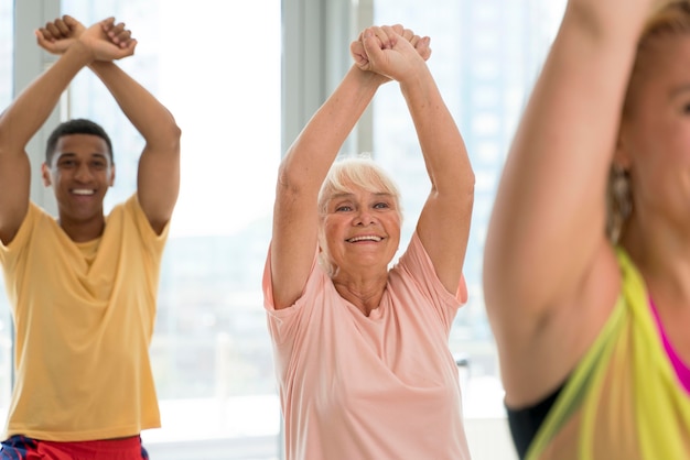 Gente sonriente divirtiéndose en clase de zumba