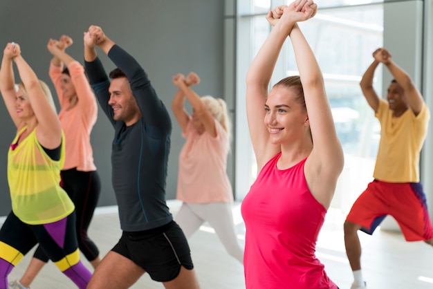 Gente sonriente divirtiéndose en clase de zumba