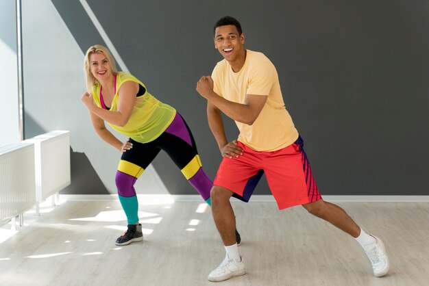 Gente sonriente divirtiéndose en clase de zumba