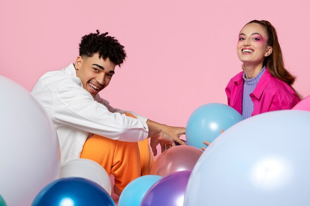 Gente sonriente jugando con globo tiro medio