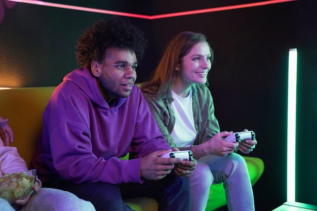 Gente sonriente jugando videojuegos en el interior